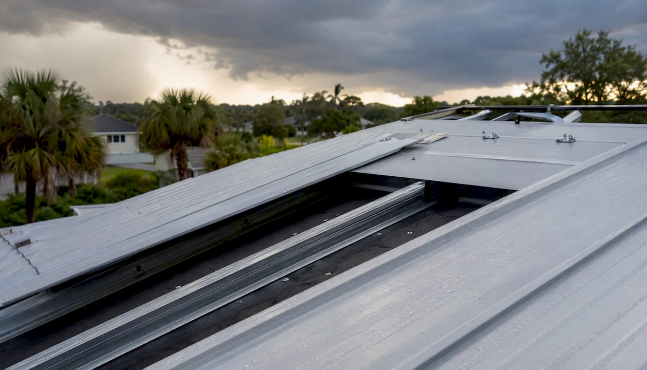 Metal roof retrofit mid-installation with storm clouds