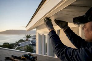 Hands installing soffit and fascia panels