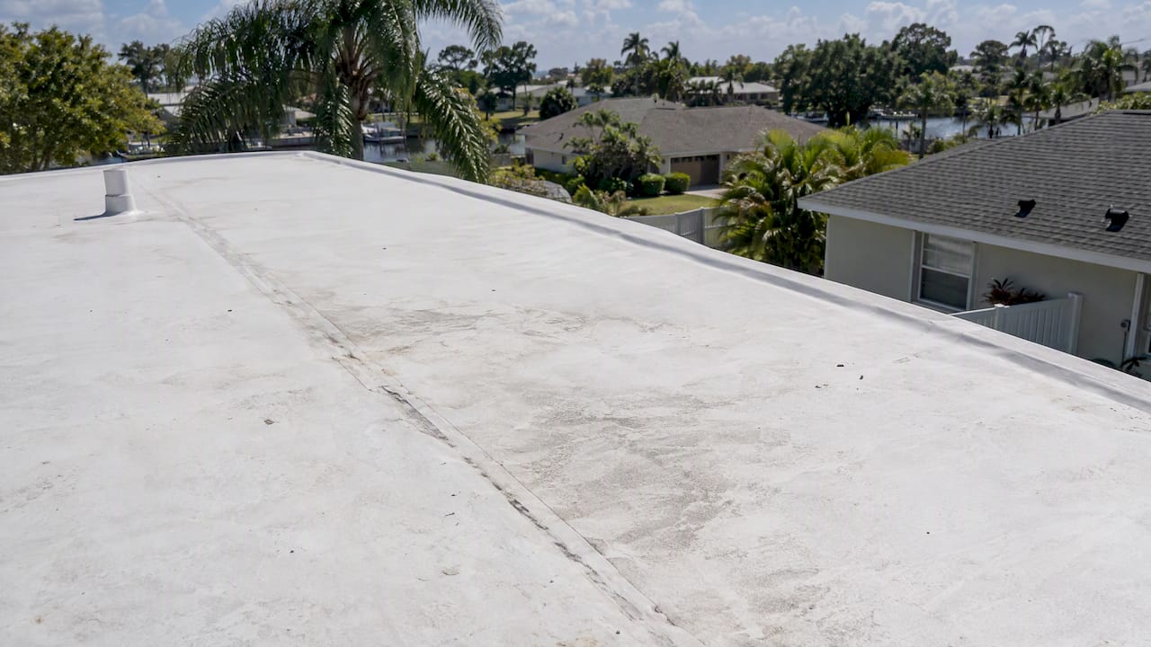 Coastal Roofing & Construction LLC | TPO Roof Lifespan in Florida: What to Realistically Expect Weathered TPO membrane on a Florida home